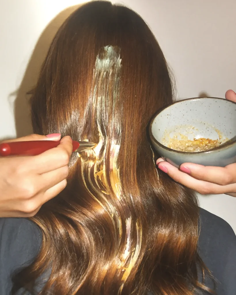 Kleurspecialist brengt met een kwast balayage aan in lang bruin haar